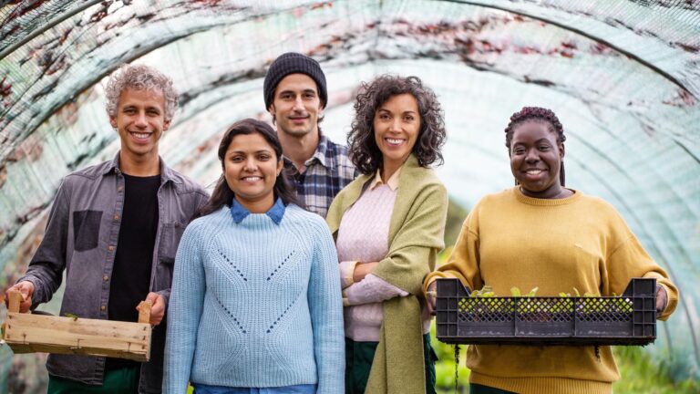 Group of people smiling holding produce