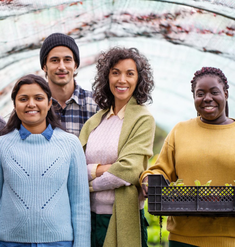 Group of people smiling and holding produce